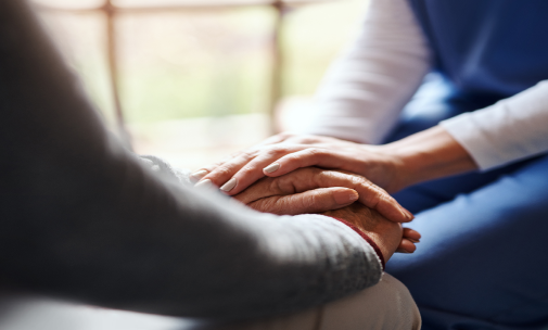 Caregiver holding patient's hands